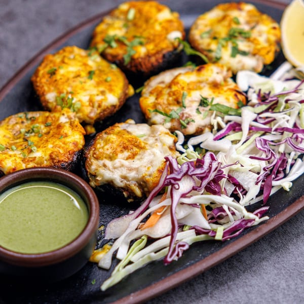 Indian stuffed mushrooms with cheese, green sauce, and a side of shredded cabbage salad.